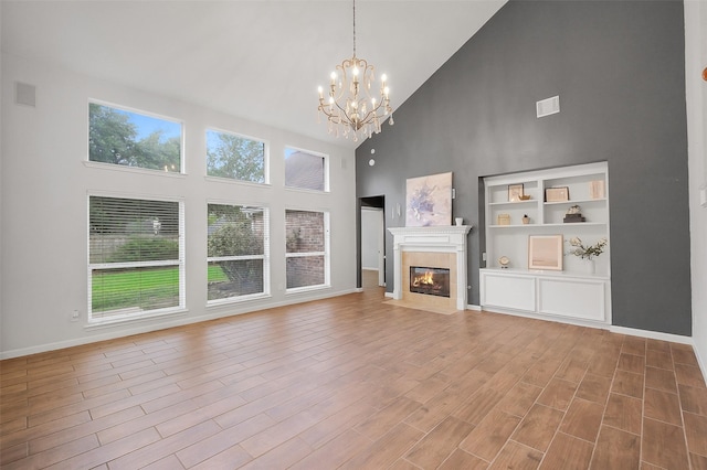 3606 Mira Glen Dr, Pearland, TX 77584 - unfurnished living room with high vaulted ceiling, a chandelier, a fireplace, baseboards, and wood finished floors