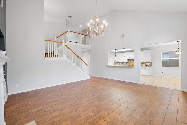 3606 Mira Glen Dr, Pearland, TX 77584 - unfurnished living room featuring stairway, light wood-style floors, a chandelier, high vaulted ceiling, and baseboards
