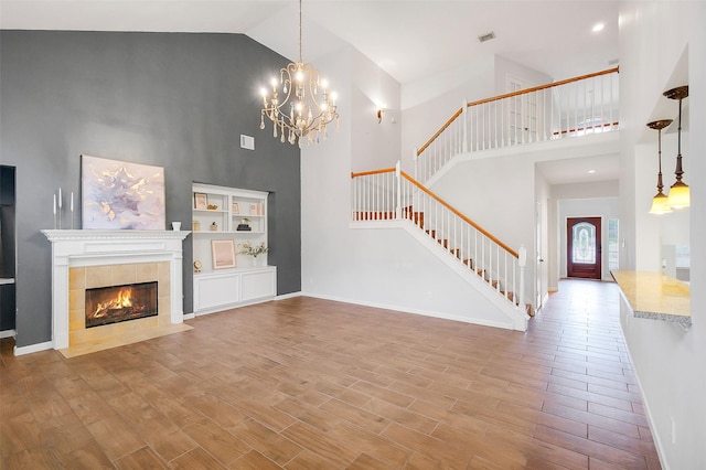 3606 Mira Glen Dr, Pearland, TX 77584 - unfurnished living room with high vaulted ceiling, stairs, wood finished floors, baseboards, and a chandelier