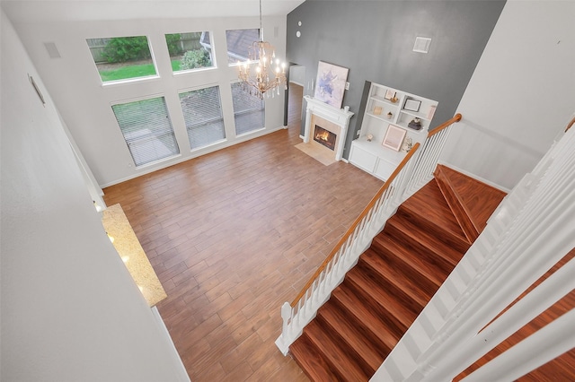 3606 Mira Glen Dr, Pearland, TX 77584 - stairs with a chandelier, a high ceiling, wood finished floors, and a high end fireplace