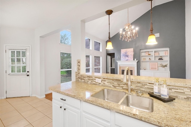 3606 Mira Glen Dr, Pearland, TX 77584 - kitchen featuring a sink, high vaulted ceiling, light tile patterned flooring, light stone counters, and decorative backsplash
