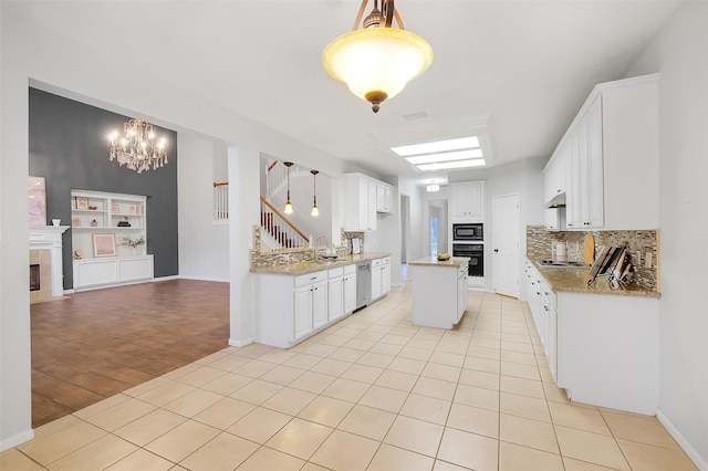 3606 Mira Glen Dr, Pearland, TX 77584 - kitchen with a tile fireplace, black appliances, light tile patterned floors, and white cabinets