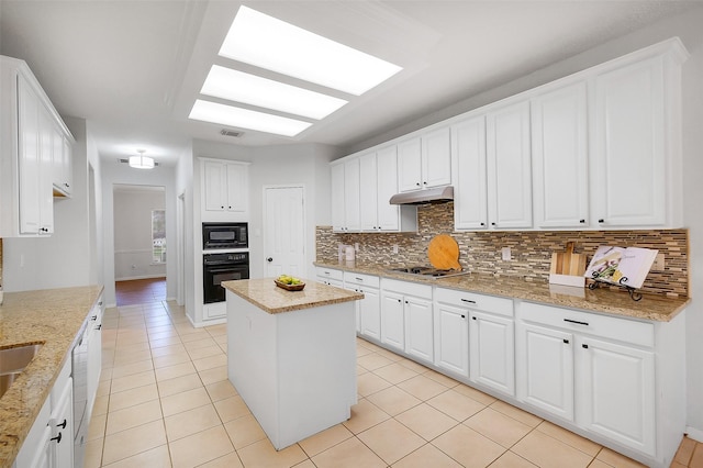 3606 Mira Glen Dr, Pearland, TX 77584 - kitchen with black appliances, tasteful backsplash, under cabinet range hood, light tile patterned floors, and white cabinetry