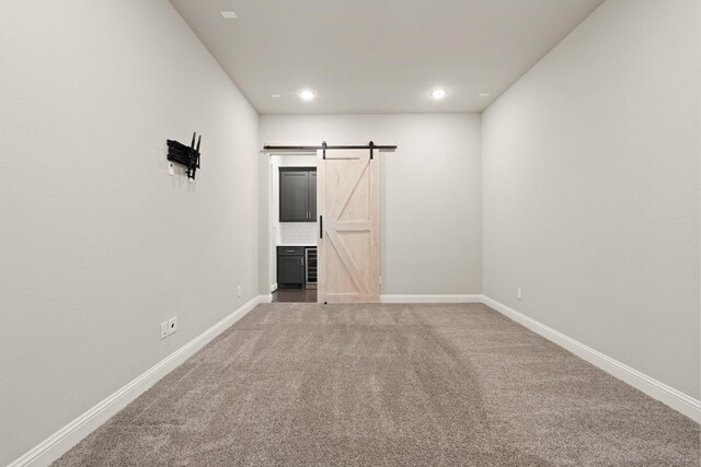 27423 Parker Spring Ct, Katy, TX 77494 - carpeted empty room featuring a barn door, baseboards, and recessed lighting