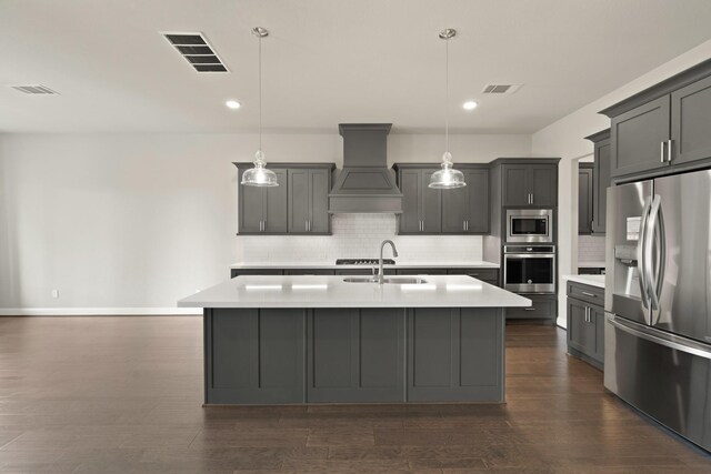 27423 Parker Spring Ct, Katy, TX 77494 - kitchen featuring stainless steel appliances, a sink, custom exhaust hood, light countertops, and recessed lighting