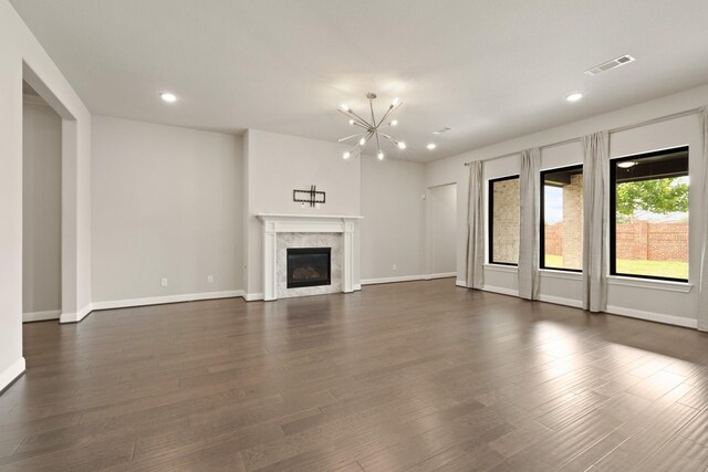 27423 Parker Spring Ct, Katy, TX 77494 - unfurnished living room featuring recessed lighting, a chandelier, baseboards, dark wood-type flooring, and a premium fireplace