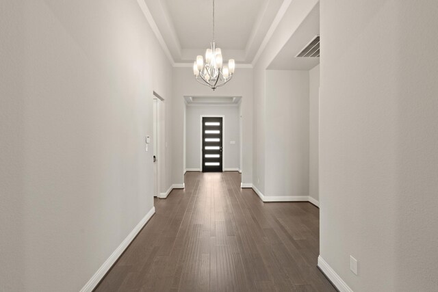 27423 Parker Spring Ct, Katy, TX 77494 - hall with a chandelier, dark wood-type flooring, baseboards, ornamental molding, and a tray ceiling