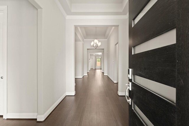 27423 Parker Spring Ct, Katy, TX 77494 - corridor with a chandelier, baseboards, dark wood-style flooring, a tray ceiling, and crown molding
