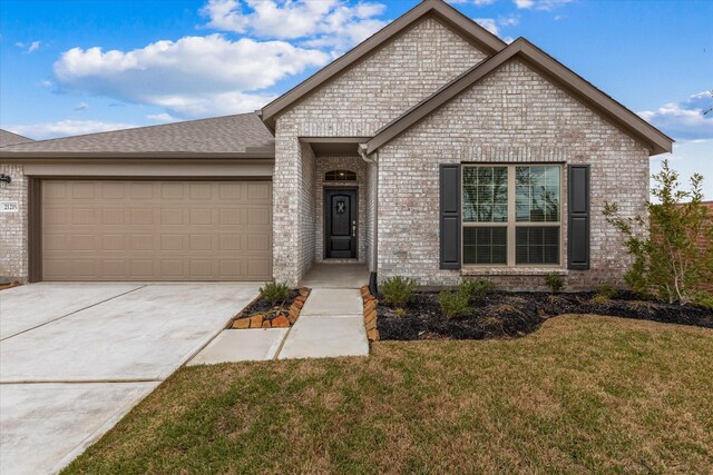 21219 Mangrove Ln, Cypress, TX 77433 - view of front facade featuring brick siding, a front lawn, a garage, concrete driveway, and a shingled roof