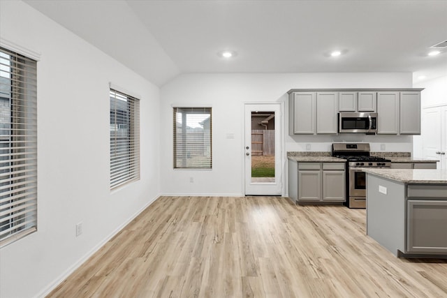 21219 Mangrove Ln, Cypress, TX 77433 - kitchen with gray cabinets, stainless steel appliances, light wood-type flooring, light stone countertops, and recessed lighting