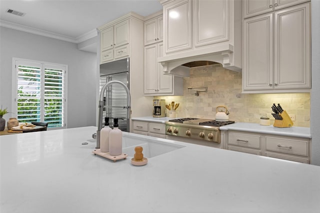 7 Woodglade Way, Tomball, TX 77375 - kitchen with light countertops, stainless steel gas cooktop, crown molding, tasteful backsplash, and a sink