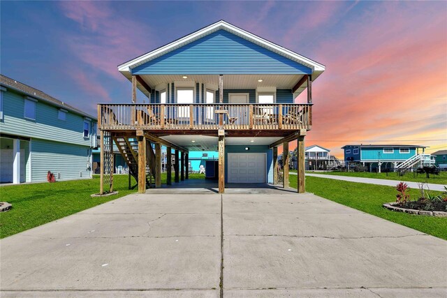 4023 Grayson Dr, Galveston, TX 77554 - beach home with a carport, a porch, a garage, driveway, and a lawn