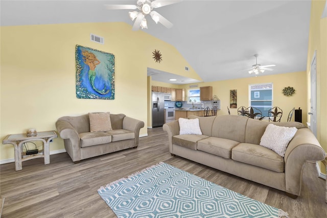 4023 Grayson Dr, Galveston, TX 77554 - living area featuring a ceiling fan, vaulted ceiling, light wood-style flooring, and baseboards
