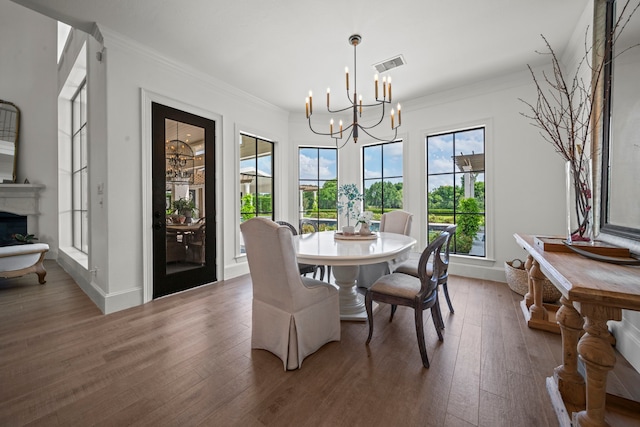 23323 Two Harbors Glen St, Katy, TX 77494 - dining area featuring a chandelier, wood finished floors, crown molding, baseboards, and a fireplace