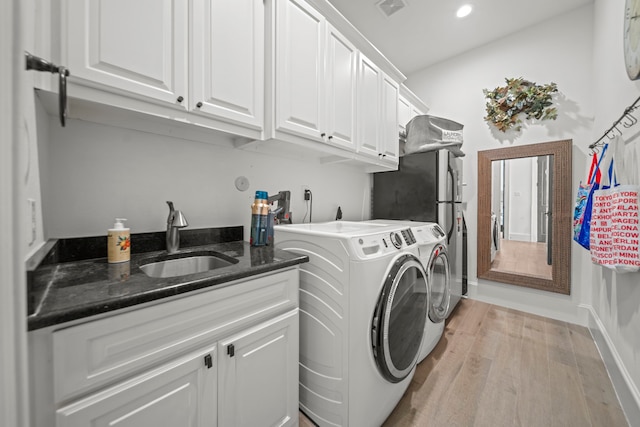 23323 Two Harbors Glen St, Katy, TX 77494 - laundry room featuring independent washer and dryer, light wood-style floors, cabinet space, and recessed lighting