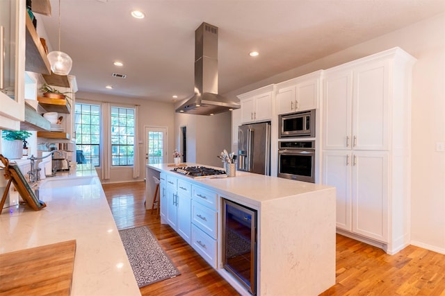 5343 Appleblossom Ln, Friendswood, TX 77546 - kitchen with appliances with stainless steel finishes, wine cooler, range hood, white cabinetry, and light countertops