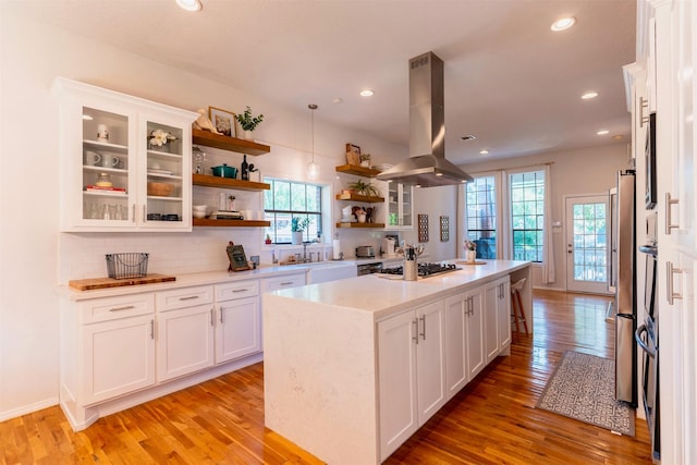 5343 Appleblossom Ln, Friendswood, TX 77546 - kitchen with island range hood, open shelves, healthy amount of natural light, white cabinetry, and recessed lighting