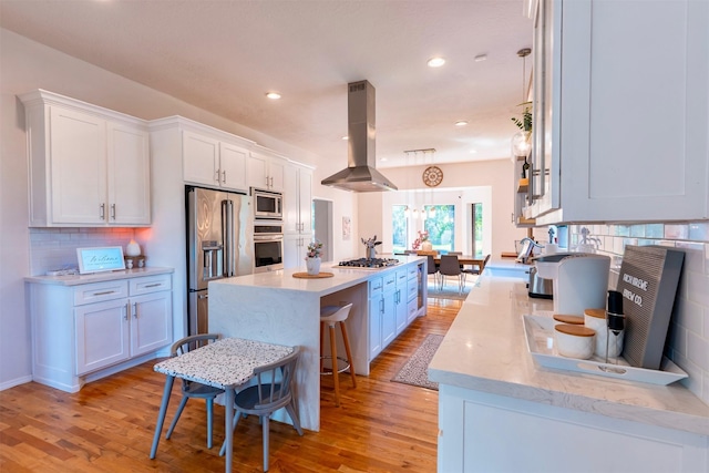 5343 Appleblossom Ln, Friendswood, TX 77546 - kitchen with island range hood, appliances with stainless steel finishes, a center island, light wood-type flooring, and white cabinets