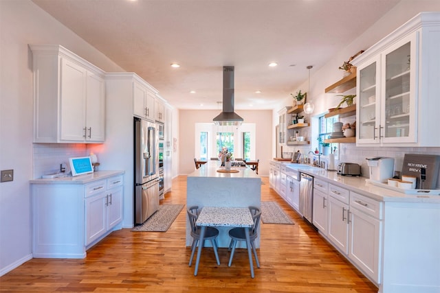 5343 Appleblossom Ln, Friendswood, TX 77546 - kitchen featuring a center island, appliances with stainless steel finishes, island range hood, open shelves, and light countertops