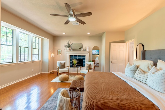 5343 Appleblossom Ln, Friendswood, TX 77546 - bedroom featuring wood finished floors, a tiled fireplace, and a ceiling fan