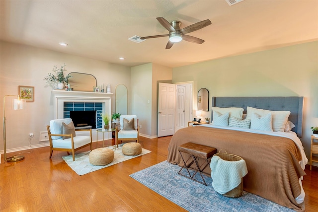 5343 Appleblossom Ln, Friendswood, TX 77546 - bedroom featuring wood finished floors, a tile fireplace, a ceiling fan, and recessed lighting