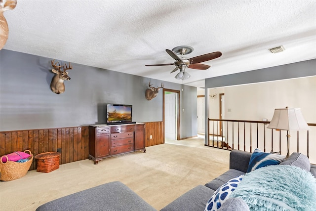 20131 Magnolia Bend Dr, Humble, TX 77346 - living area featuring light colored carpet, wainscoting, a ceiling fan, a textured ceiling, and wooden walls