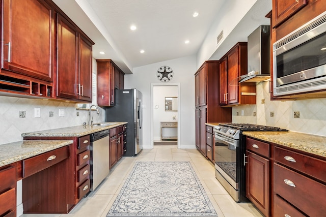 9123 Kapri Ln, Houston, TX 77025 - kitchen featuring appliances with stainless steel finishes, dark brown cabinets, wall chimney exhaust hood, a sink, and light stone counters
