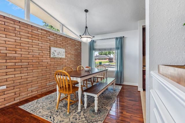 9123 Kapri Ln, Houston, TX 77025 - dining area featuring brick wall, wood finished floors, lofted ceiling, and baseboards