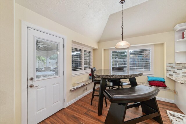20107 Black Canyon Dr, Katy, TX 77450 - dining area featuring vaulted ceiling, dark wood-style floors, baseboards, breakfast area, and a textured ceiling
