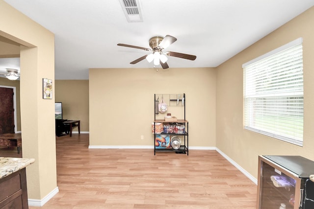 5423 Lillian St, Baytown, TX 77521 - living area with ceiling fan, light wood-type flooring, wine cooler, and baseboards