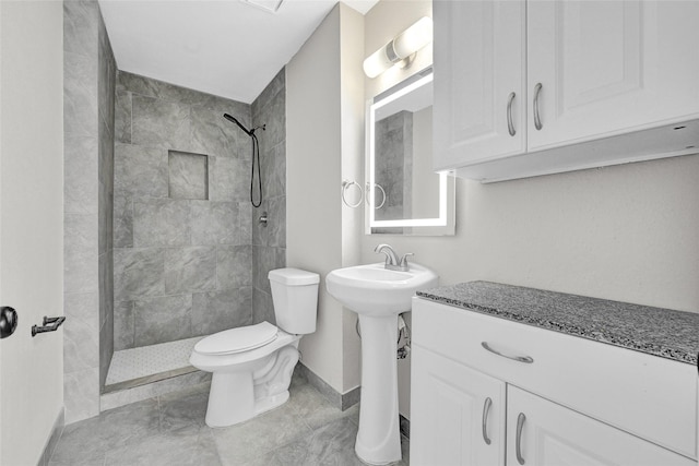11871 Algonquin Dr, Houston, TX 77089 - full bathroom with toilet, tiled shower, baseboards, tile patterned floors, and a sink