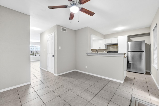 11871 Algonquin Dr, Houston, TX 77089 - kitchen with freestanding refrigerator, light tile patterned floors, white cabinets, under cabinet range hood, and a ceiling fan