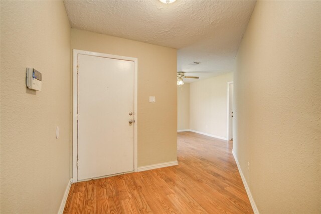 9831 Shell Rock Rd, La Porte, TX 77571 - corridor featuring light wood-style floors, a textured ceiling, and baseboards