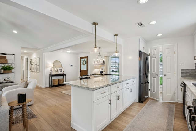10622 Wickersham Ln, Houston, TX 77042 - kitchen with freestanding refrigerator, open floor plan, a peninsula, white cabinetry, and recessed lighting