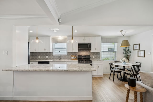10622 Wickersham Ln, Houston, TX 77042 - kitchen with stainless steel microwave, gas range oven, a sink, white cabinetry, and backsplash