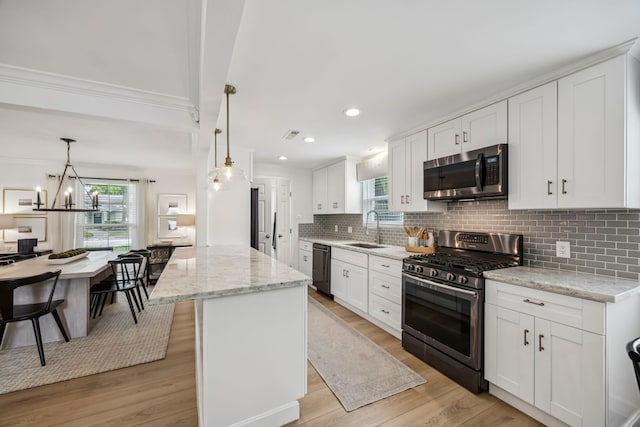 10622 Wickersham Ln, Houston, TX 77042 - kitchen featuring appliances with stainless steel finishes, a sink, crown molding, white cabinets, and tasteful backsplash