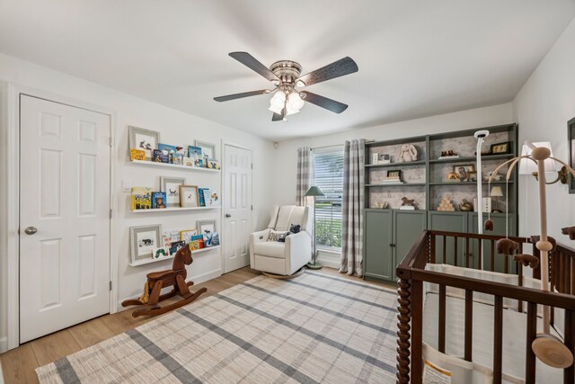 10622 Wickersham Ln, Houston, TX 77042 - bedroom featuring a nursery area, light wood-style flooring, and a ceiling fan