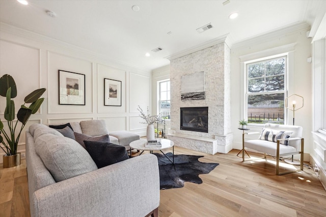 432 Marshall St, Houston, TX 77006 - living room featuring a decorative wall, ornamental molding, healthy amount of natural light, a stone fireplace, and wood finished floors