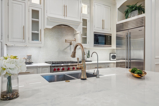 432 Marshall St, Houston, TX 77006 - kitchen with built in appliances, tasteful backsplash, a sink, and white cabinets