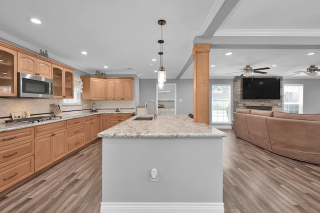 833 Stone Mountain Dr, Conroe, TX 77302 - kitchen featuring stainless steel appliances, a sink, crown molding, open floor plan, and light wood-style flooring