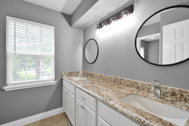 833 Stone Mountain Dr, Conroe, TX 77302 - bathroom featuring healthy amount of natural light, double vanity, baseboards, and tile patterned flooring
