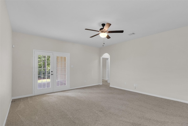 7571 Fettle Ln, Conroe, TX 77304 - carpeted spare room with arched walkways, a ceiling fan, baseboards, and french doors