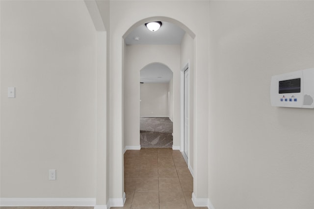 7571 Fettle Ln, Conroe, TX 77304 - corridor with arched walkways, light tile patterned floors, and baseboards