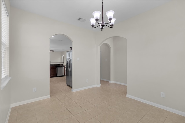 7571 Fettle Ln, Conroe, TX 77304 - spare room with arched walkways, a chandelier, light tile patterned floors, and baseboards