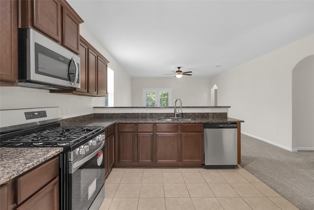 7571 Fettle Ln, Conroe, TX 77304 - kitchen with appliances with stainless steel finishes, arched walkways, a sink, ceiling fan, and a peninsula