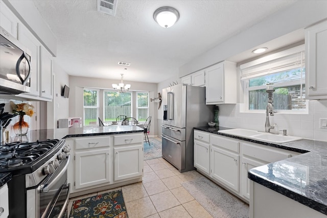 30307 Thorsby Dr, Spring, TX 77386 - kitchen with appliances with stainless steel finishes, a sink, a chandelier, white cabinets, and backsplash