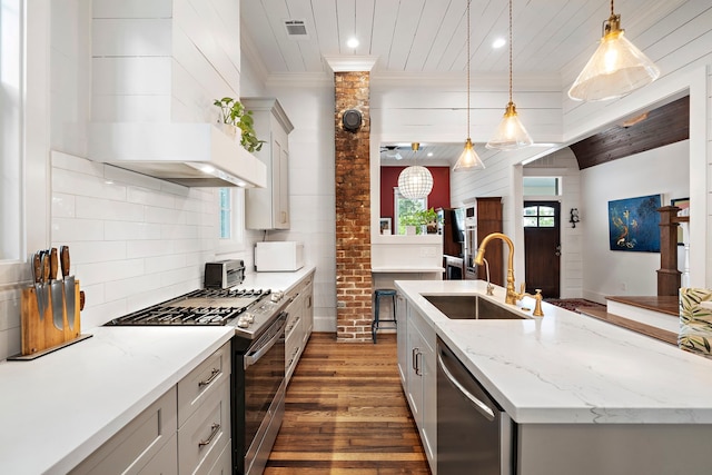 2019 Crockett St, Houston, TX 77007 - kitchen with stainless steel appliances, a sink, dark wood-style flooring, ornamental molding, and decorative light fixtures