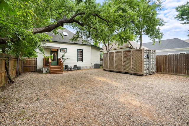 2019 Crockett St, Houston, TX 77007 - rear view of house with central AC, a fenced backyard, and a shingled roof