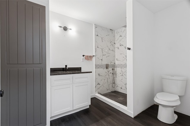 5614 Malmedy Rd, Houston, TX 77033 - full bath featuring a marble finish shower, wood finished floors, toilet, and vanity