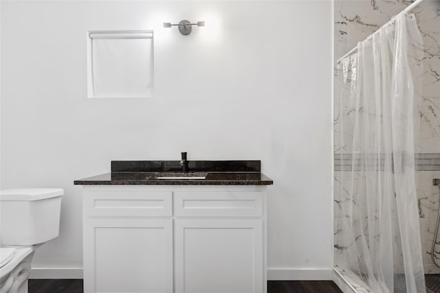 5614 Malmedy Rd, Houston, TX 77033 - full bathroom with toilet, vanity, a marble finish shower, baseboards, and wood finished floors